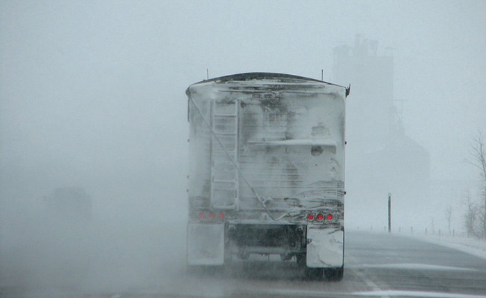 truck driving through heavy snow