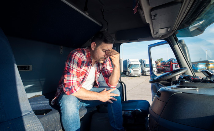 truck driver sitting in his truck cabin feeling tired