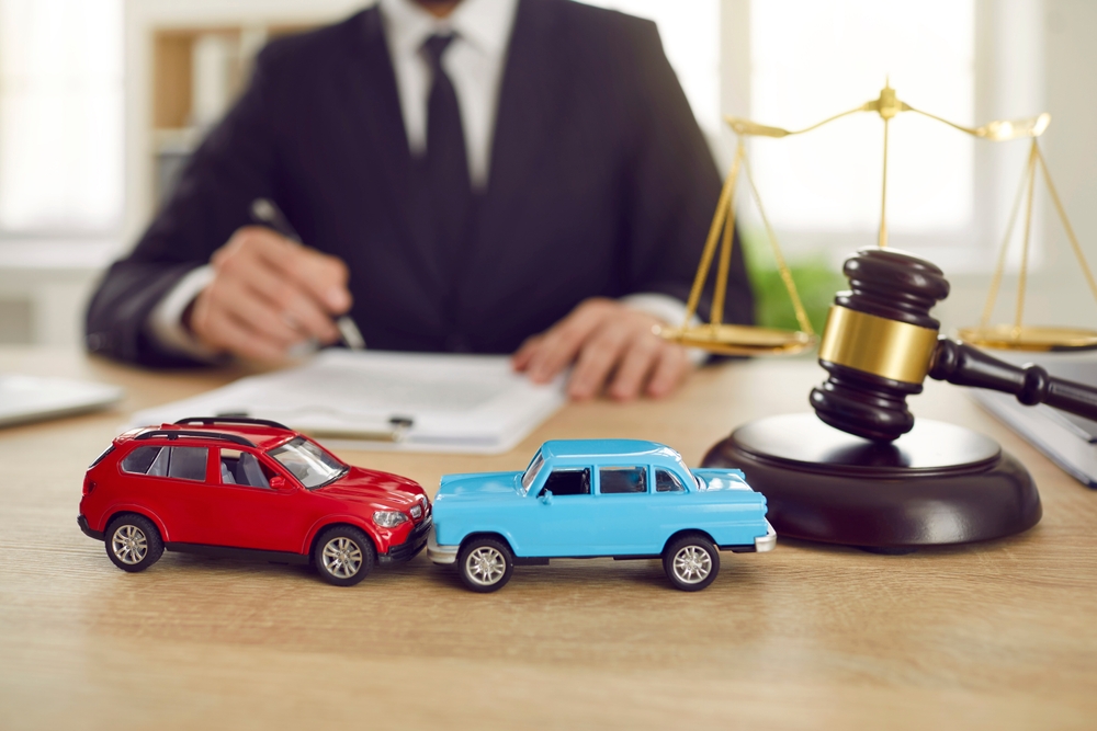 How to Determine Fault in a Rear-End Accident - Vegas Valley Injury Law Close Up of Two Toy Model Cars on Background of Lawyer