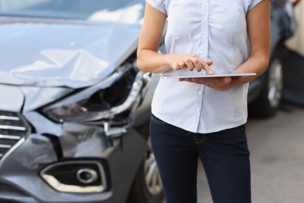 Car showing damage after an accident, with registration and insurance documents visible