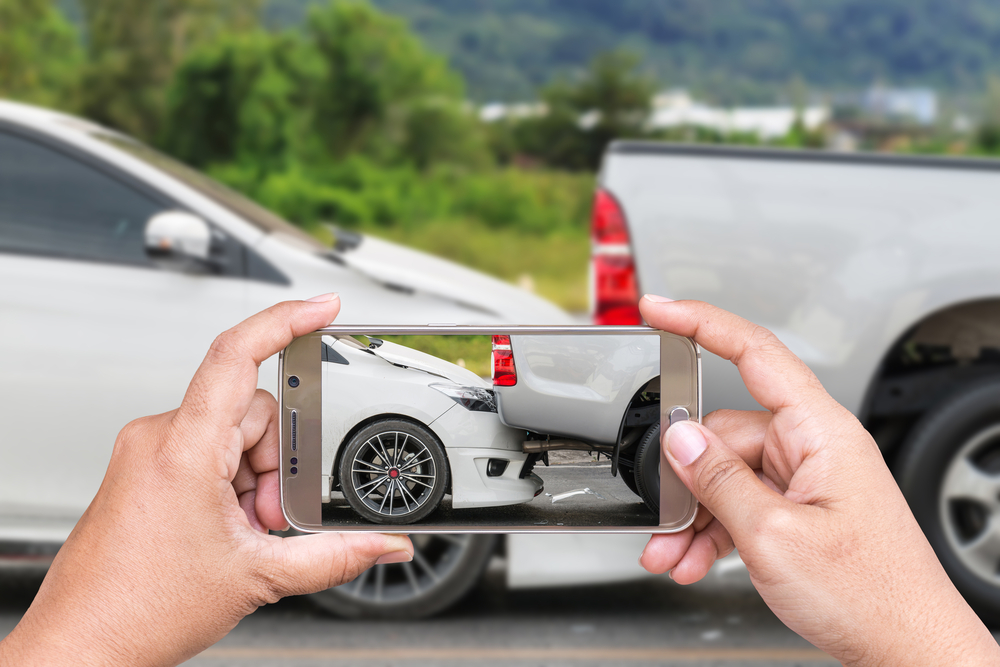 What To Do After a Car Accident: Step-by-Step Guide - Vegas Valley Injury Law Close-up of a woman’s hand holding a smartphone and taking a photo.