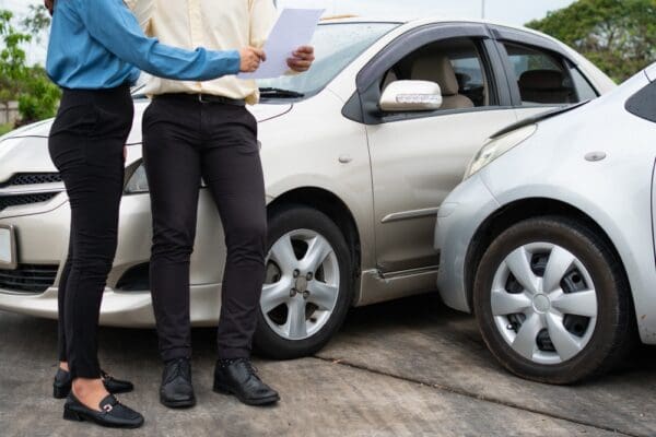 Two drivers exchanging phone numbers using a smartphone.