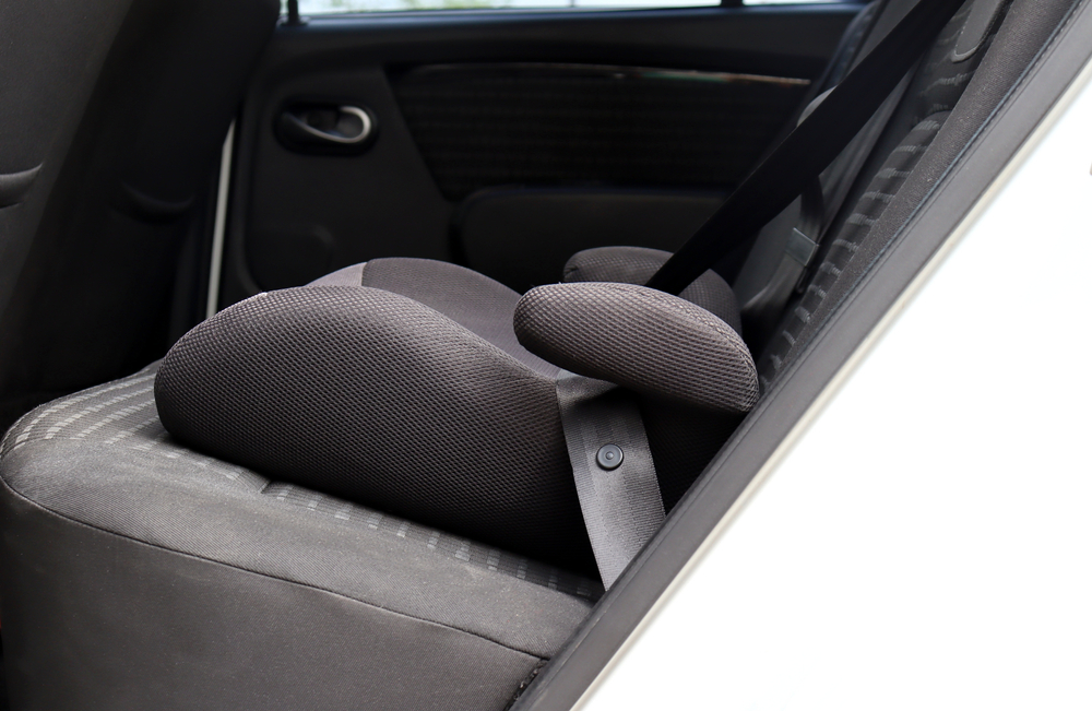 Child safety booster seat installed in a car interior